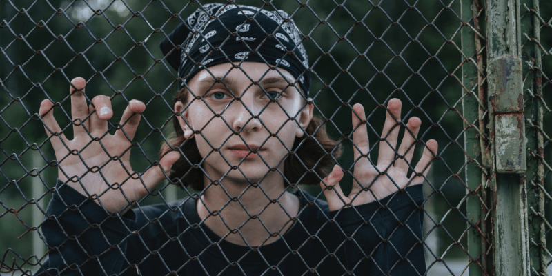 Youth behind a fence self-sabotage