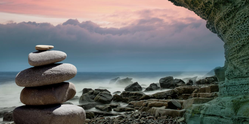 10 Resilience Strategies - stacked stones on the beach at sunset