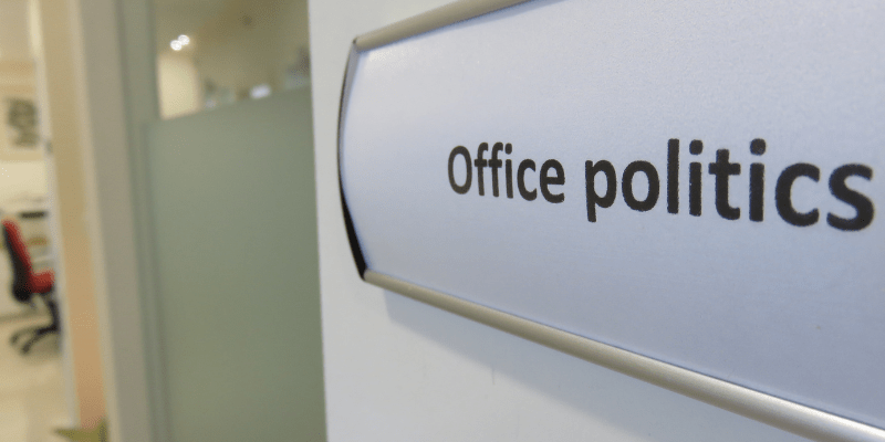 words "office politics" appears on a name plate in an office setting