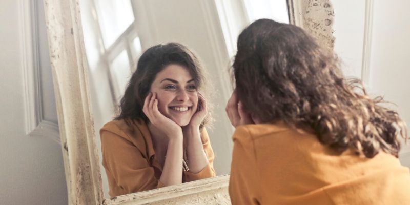 Optimal Health Quiz - woman looking in the mirror and smiling